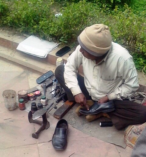 निर्माण भवन के बाहर फुटपाथ पर बैठा एक मोची। बत्तीस साल पहले से अब में मोची नहीं बदले! या बदले होंगे?