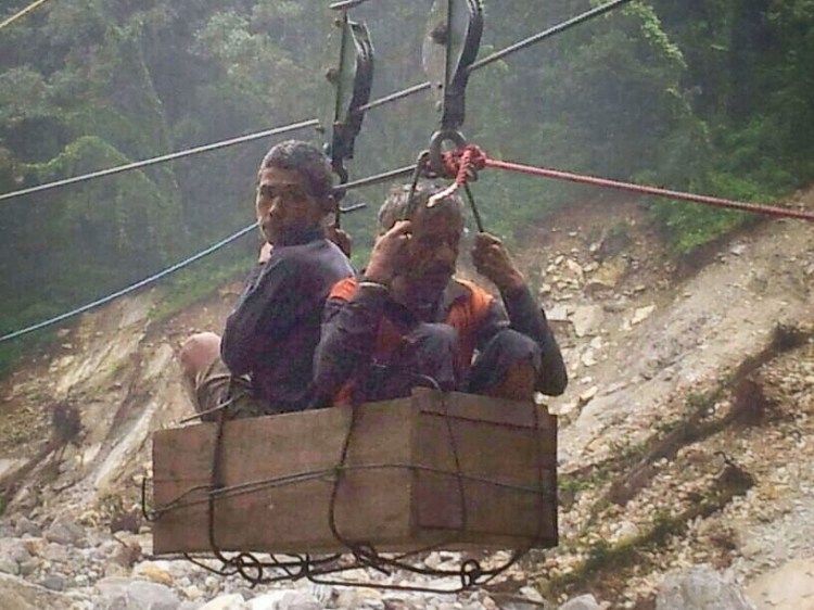 मंदाकिनी के रोप वे से नदी पार करते स्थानीय ग्रामीण। 