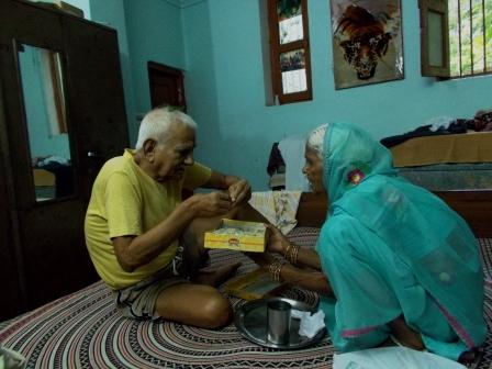 मेरी बुआ मेरे पिताजी को सिर पर जरई रख कर मिठाई खिलाती हुई। 